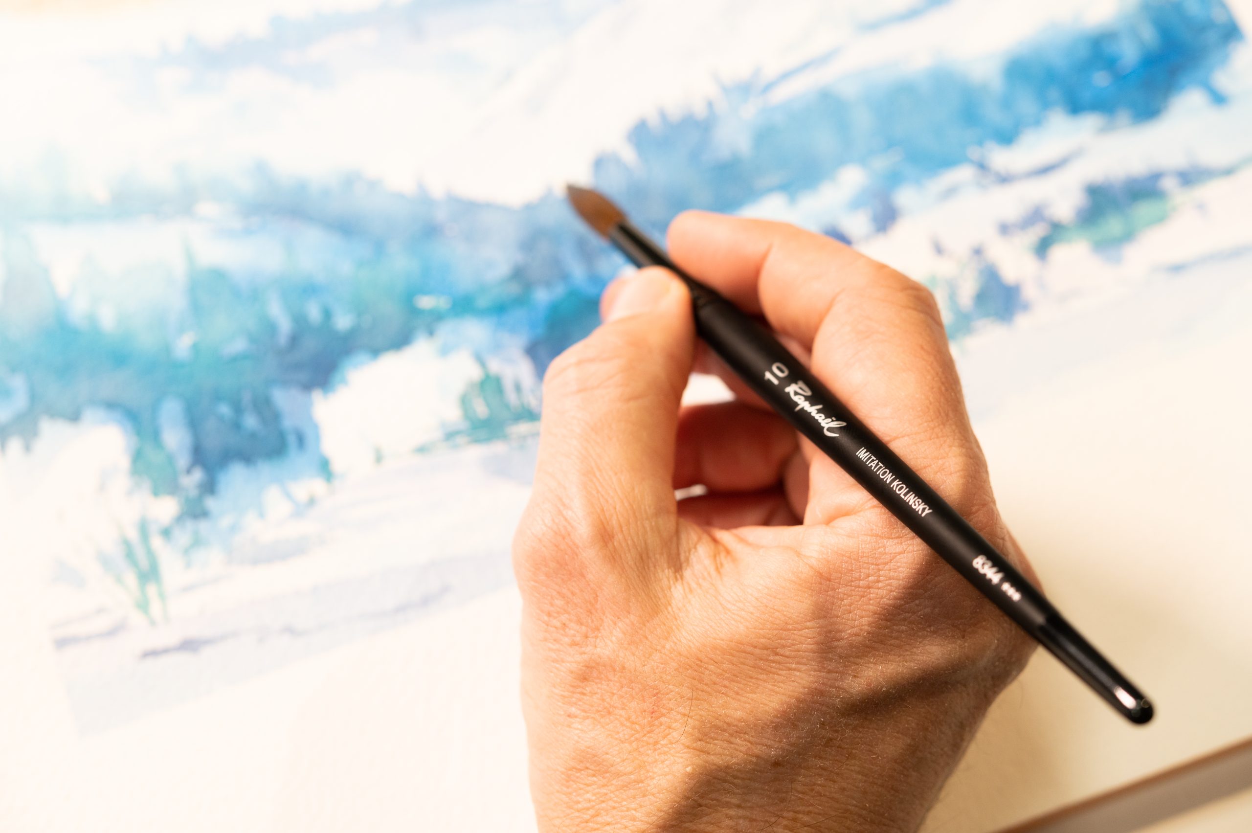 Artiste peignant à l'aquarelle avec un pinceau Stradivarius