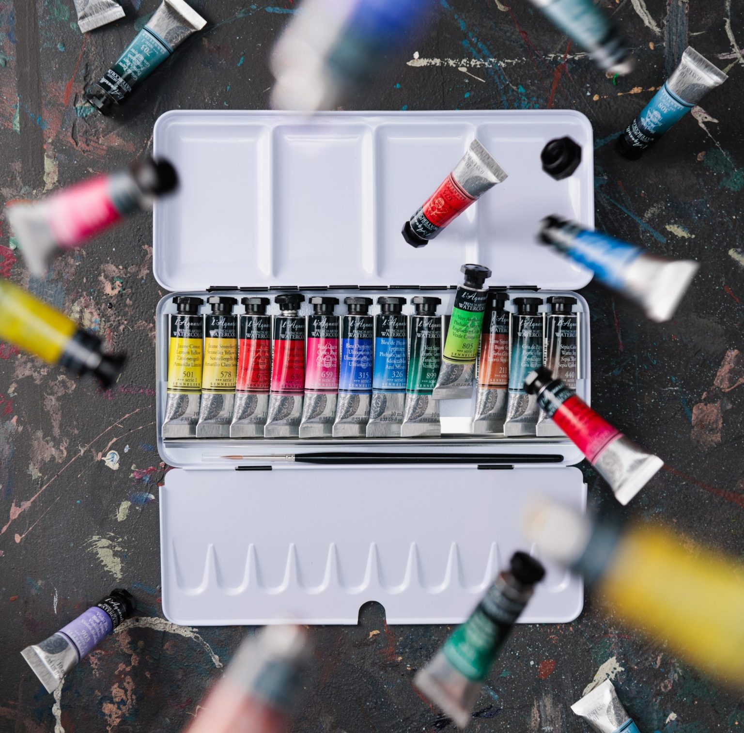 Boîte ouverte de tubes d'aquarelle extra-fine Sennelier sur fond sombre